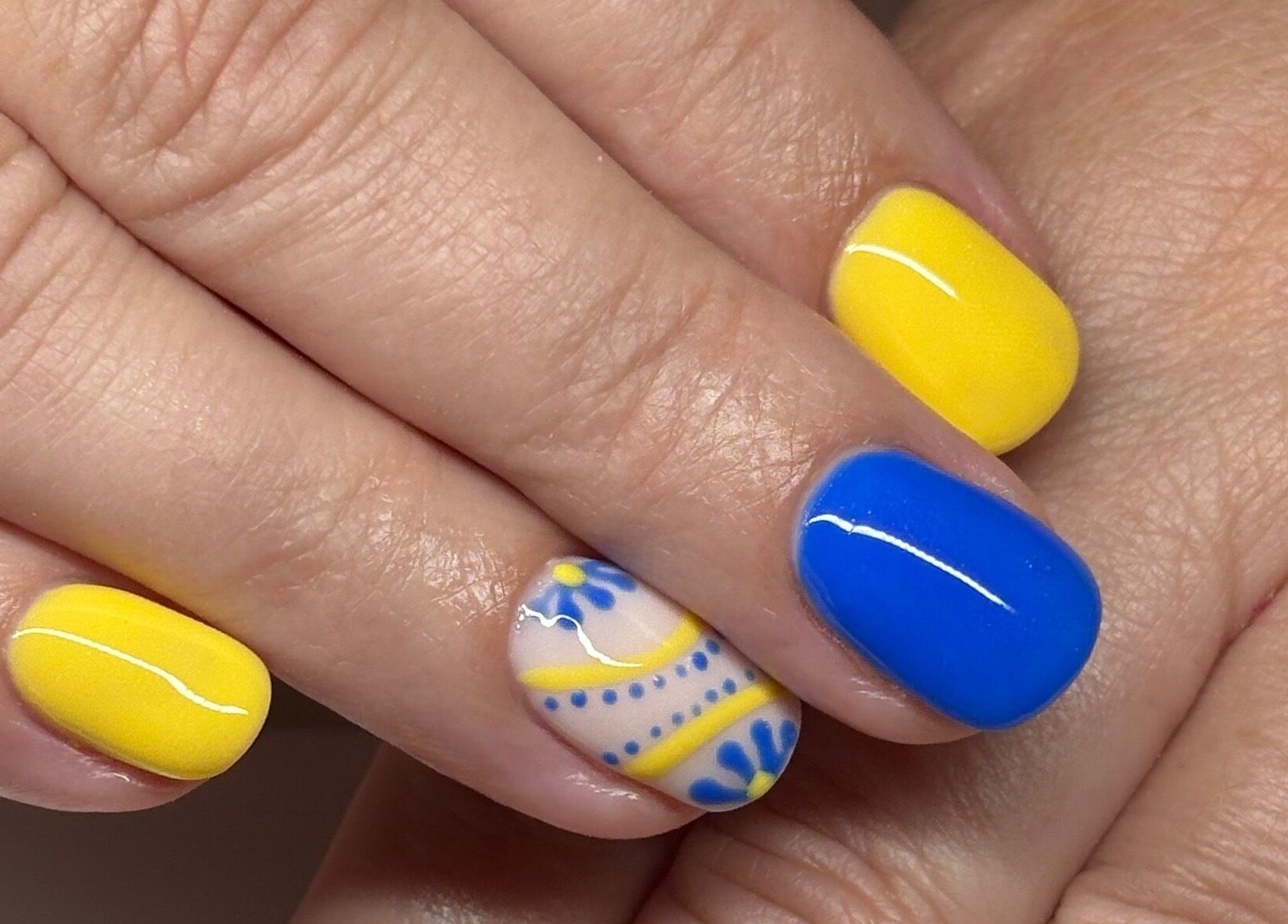 Vibrant blue and yellow nail art at Polished by Kate, Constantine, England, GB, showcasing intricate designs.