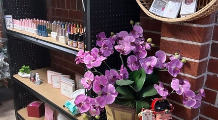 Elegant orchid display and colorful nail polish at Chester Hill nails and eyelash extension studio, Sefton, NSW, AU.