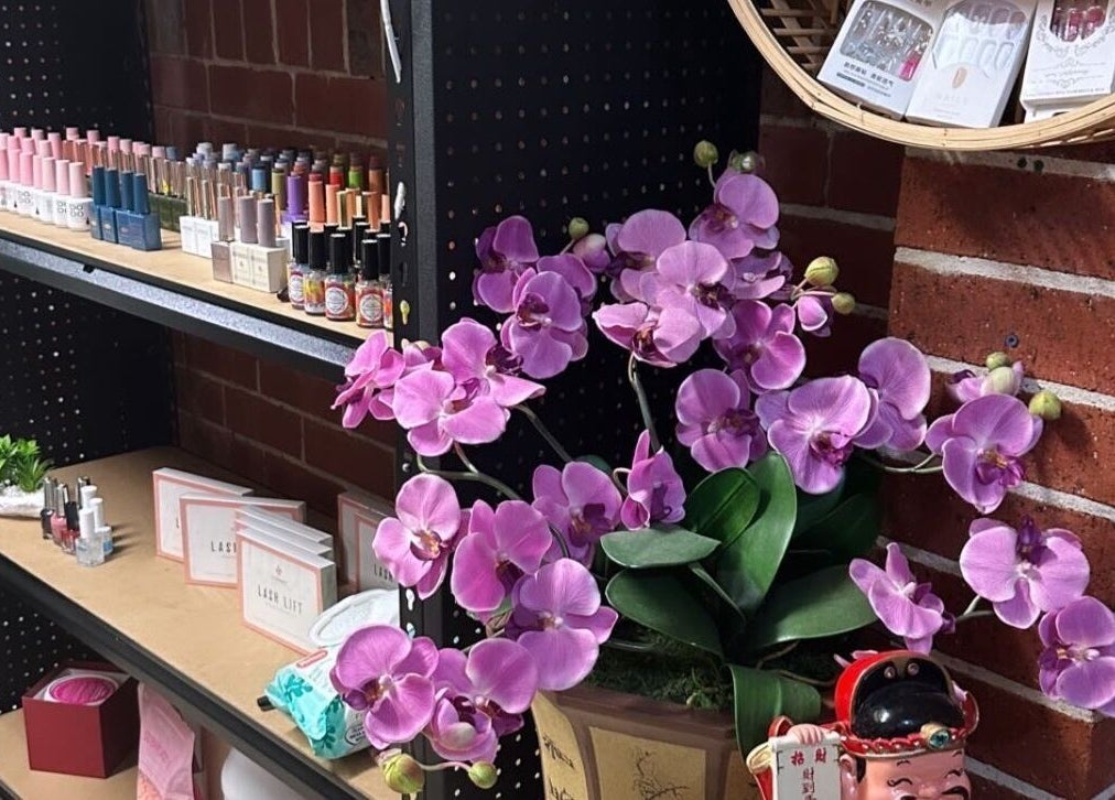 Chester Hill nails and eyelash extension studio, Sefton, New South Wales displays vibrant nail products with orchids.