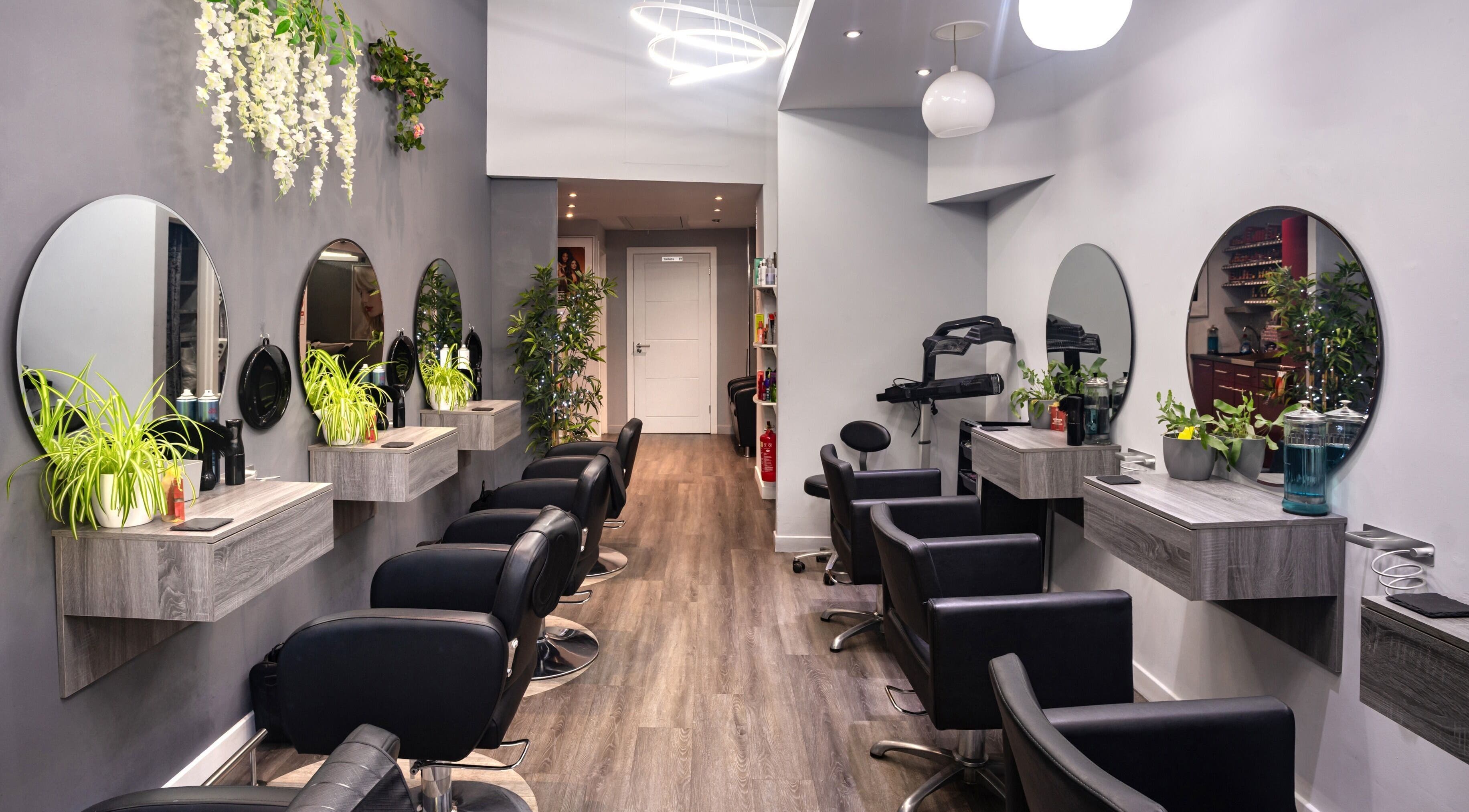 Elegant interior of E M Hair Co in Glasgow, Scotland, GB showcasing modern salon stations and decor.