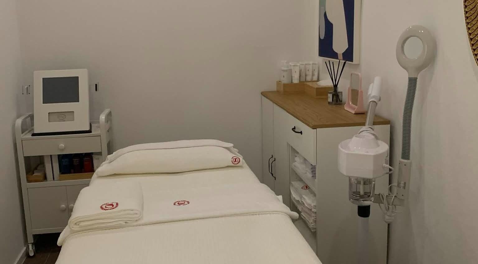 Serene treatment room at SANDHYA Wellness & Beauty, Hong Kong Island, HK, featuring cozy bed and modern equipment.
