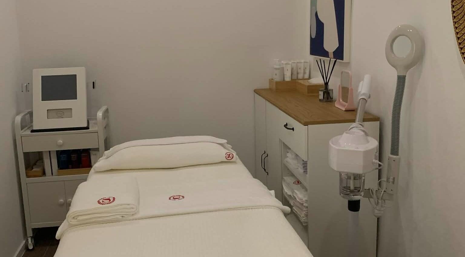 Serene treatment room at SANDHYA Wellness & Beauty, Hong Kong Island, HK, featuring cozy bed and modern equipment.