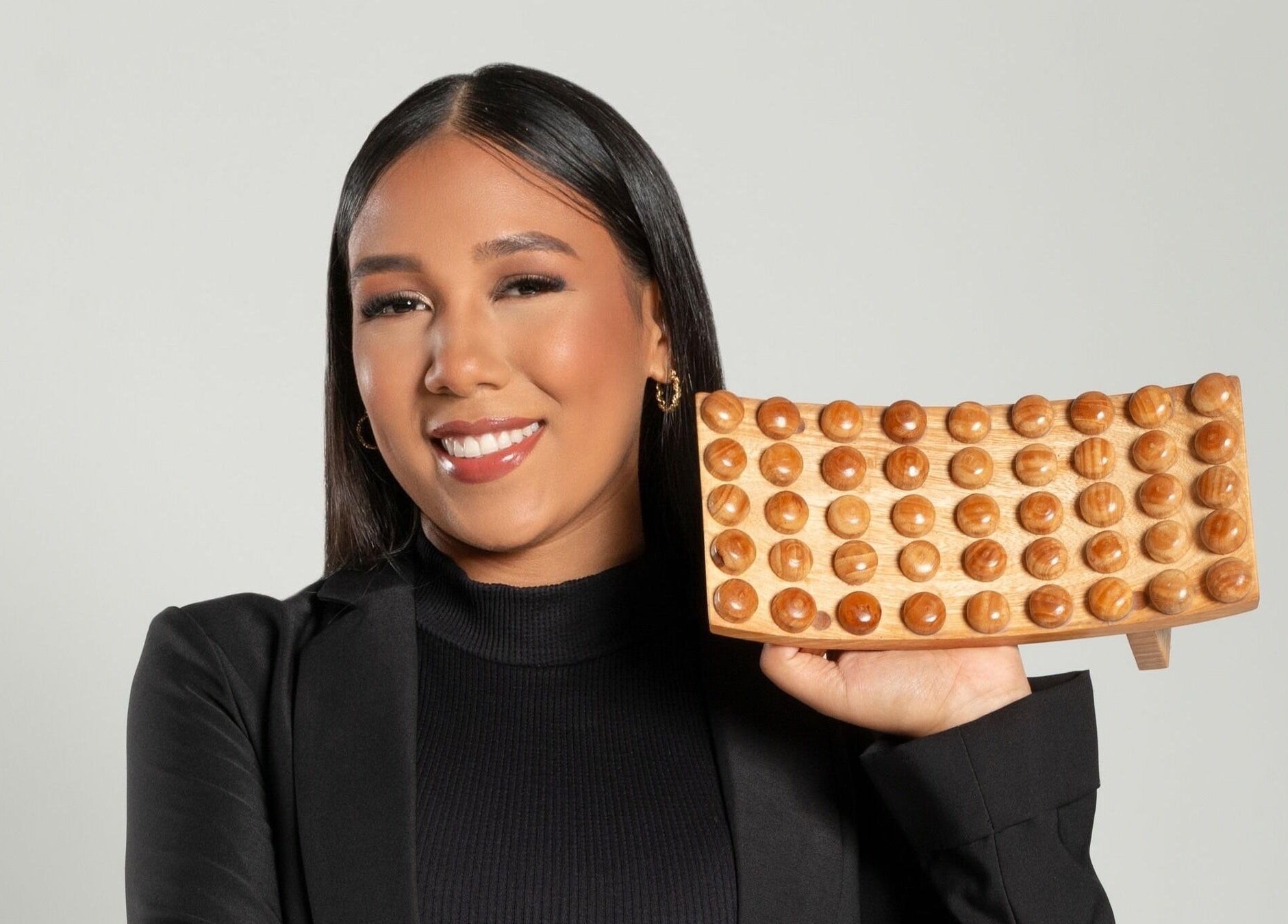 Mujer sonriente sosteniendo herramienta de masaje en Hiatus Spa, Valencia, Carabobo, VE.