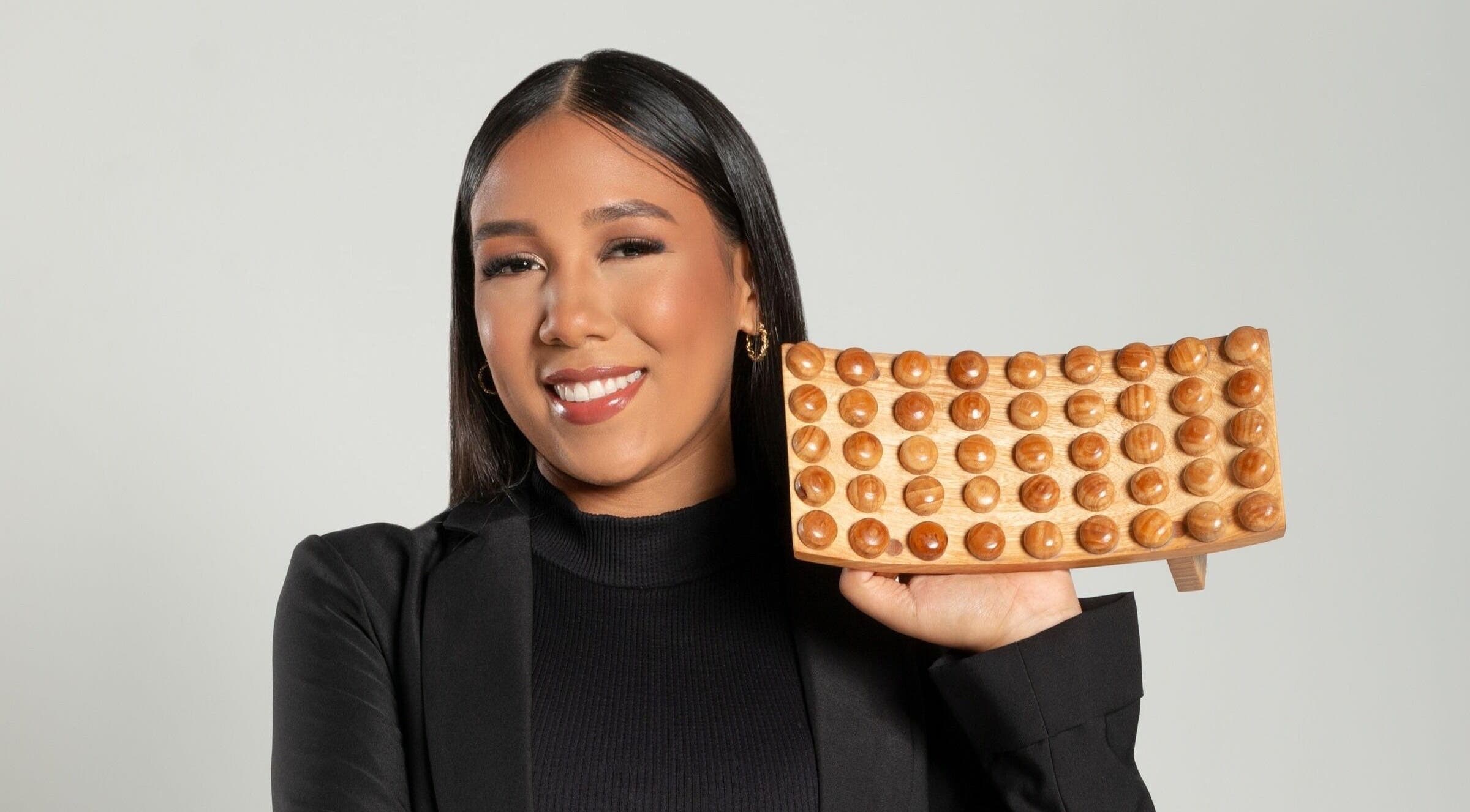 Mujer sonriente sosteniendo herramienta de masaje en Hiatus Spa, Valencia, Carabobo, VE.