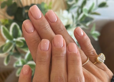 Elegant manicured nails at Lumi Nail Bar in Southport, Queensland, AU with lush green foliage backdrop.