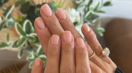 Elegant manicured nails at Lumi Nail Bar in Southport, Queensland, AU with lush green foliage backdrop.