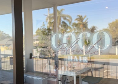 Lumi Nail Bar glass window reflection at Southport, Queensland, AU with a serene outdoor view.