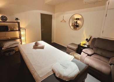 Tranquil massage room at Zen Japanese Massage Platinum in Auckland, NZ. Soft lighting and comfortable seating.