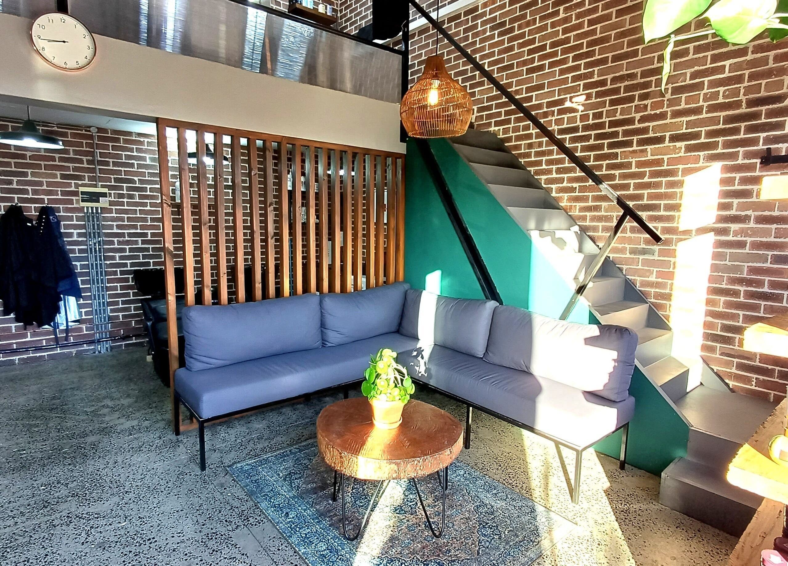 Modern lounge area at The Hadfield Hair, Cape Town, Western Cape, ZA featuring cozy seating and rustic decor.