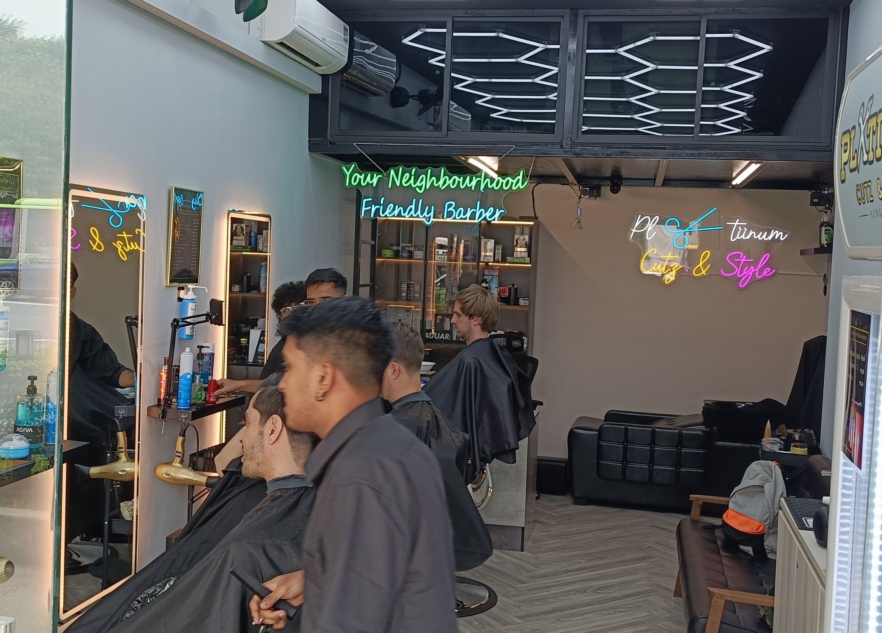 Interior of Platinum Cutz & Style - EAST on Marine Parade, Singapore, SG with vibrant decor and busy barbers.