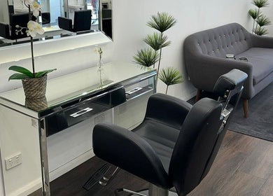 Modern seating area at V Hair Salon Bondi, Bondi, New South Wales, AU with a sleek chair and a stylish sofa.