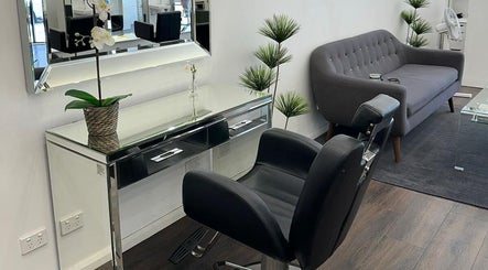 Modern seating area at V Hair Salon Bondi, Bondi, New South Wales, AU with a sleek chair and a stylish sofa.