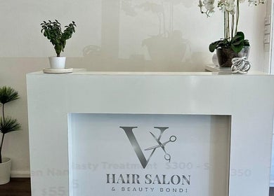 Stylish reception desk at V Hair Salon Bondi in Bondi, New South Wales, AU, featuring modern decor and greenery.
