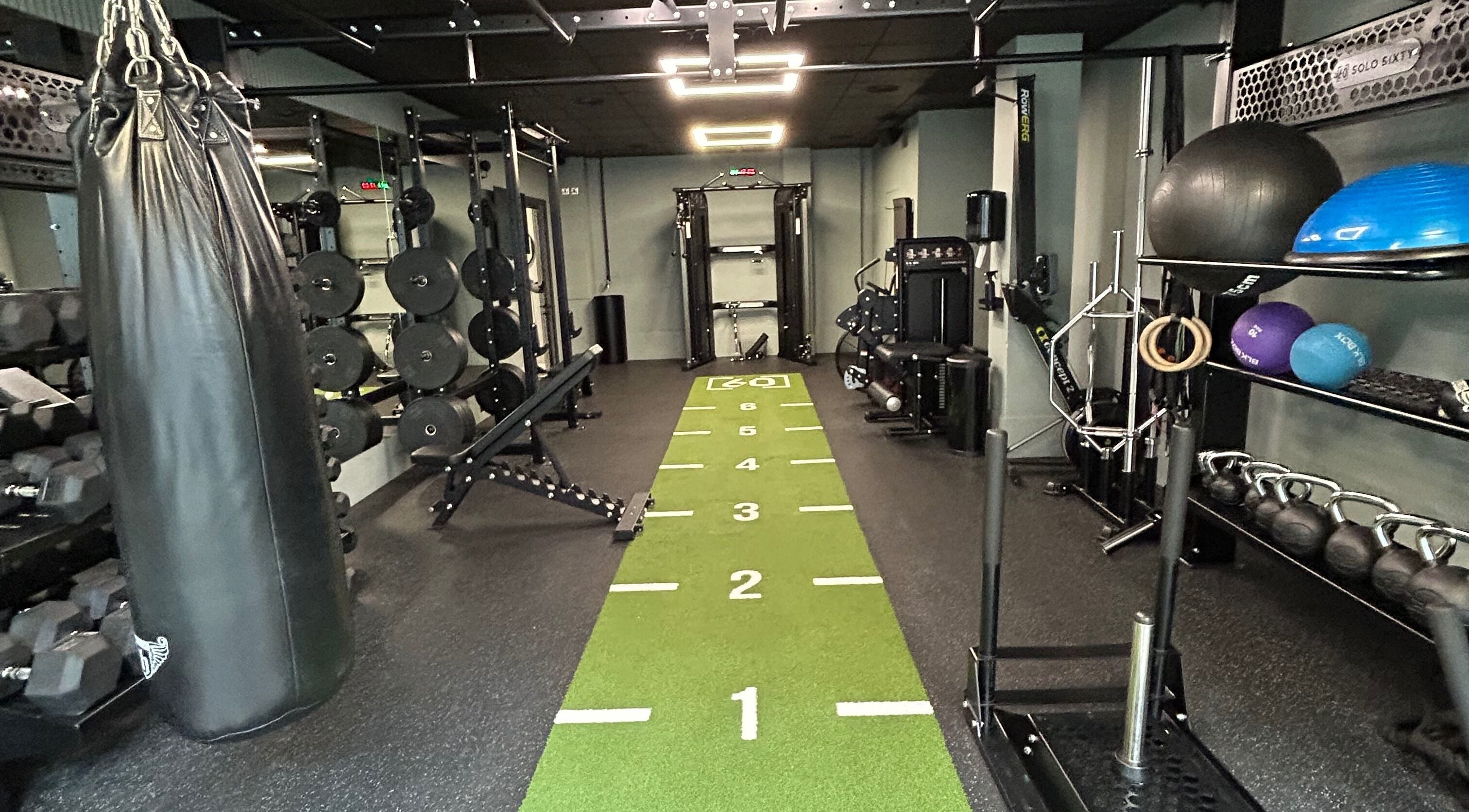 Spacious gym area at Fitness by Eddy - Personal Training, London, England, GB, featuring modern equipment and turf.