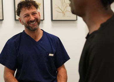 Therapist warmly welcoming client at Wellbeing Massage & Pain Relief in Covent Garden, London, England, GB.