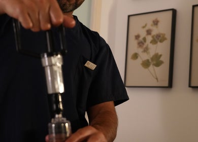 Therapist using device at Wellbeing Massage & Pain Relief in Covent Garden, London, England, GB.