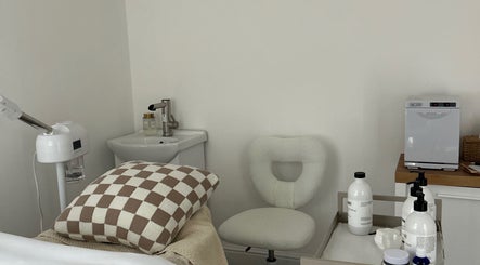 Cozy treatment room at Sara Aspinall Makeup & Skin in Birkenhead, England, GB with pillow and skincare bottles.