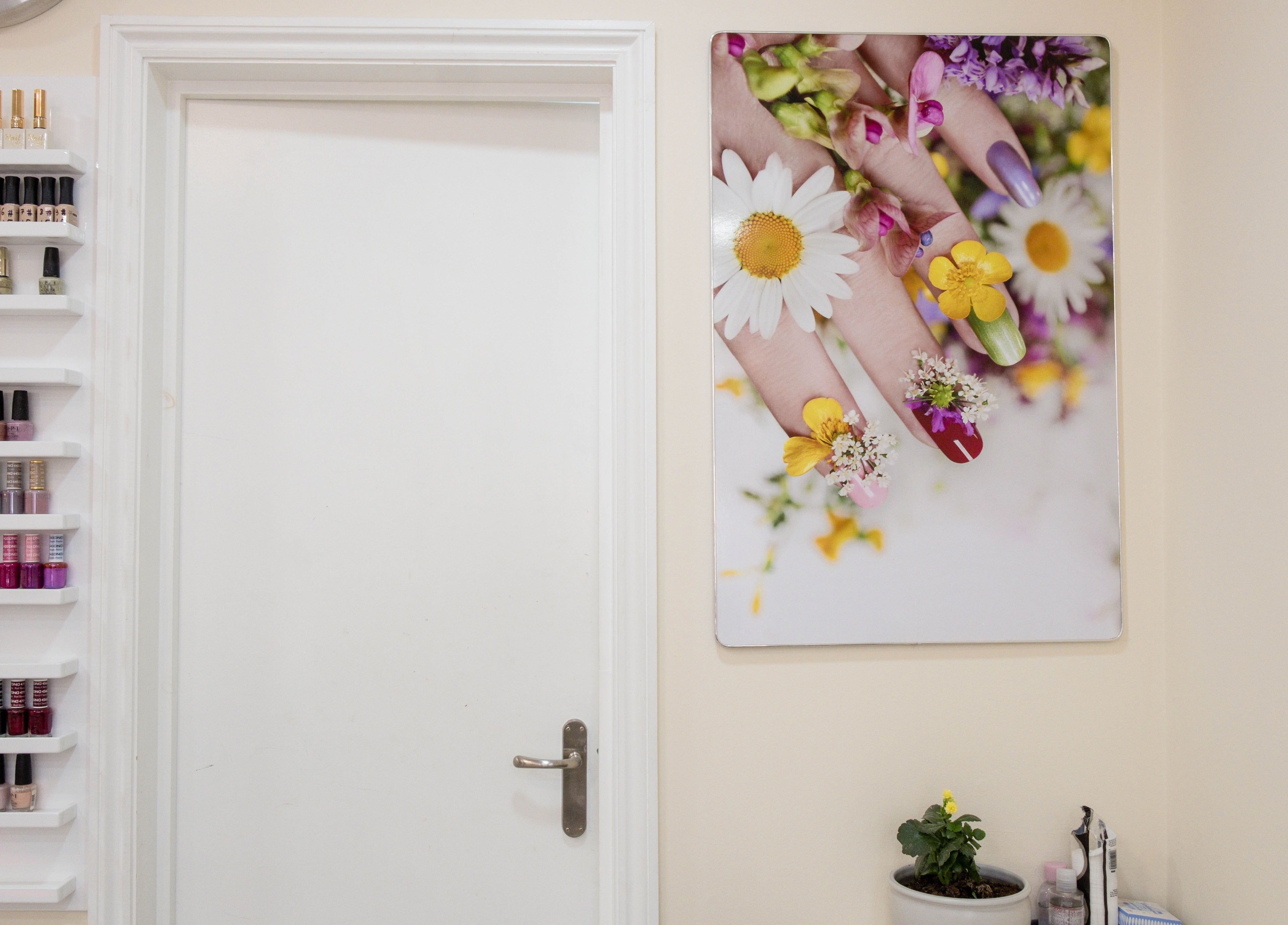 Planet Nails London showcasing vibrant nail polish display and floral nail art poster in salon interior.