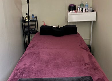 Acogedora sala de terapia en Natalia Nieves Salon, Caguas, Caguas, PR, con camilla forrada de tela púrpura.