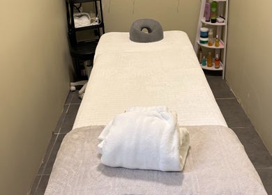 Sala de masajes en Natalia Nieves Salon, Caguas, Caguas, PR, con mesa y toallas blancas.