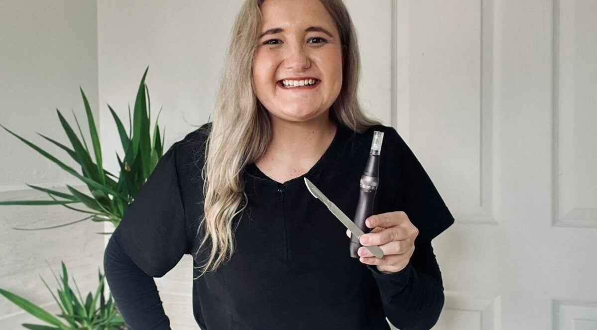 Smiling professional at KreaSkin in Emanzimtoti, Kwazulu-natal, ZA holding skincare tools.