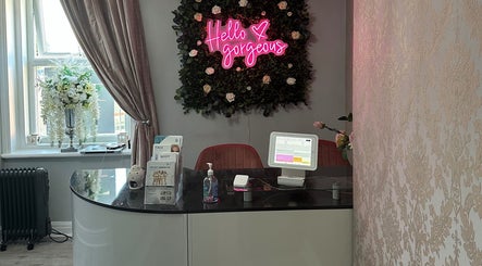 Reception at Totally Transformed, Newcastle upon Tyne, England, with floral decor and digital display.