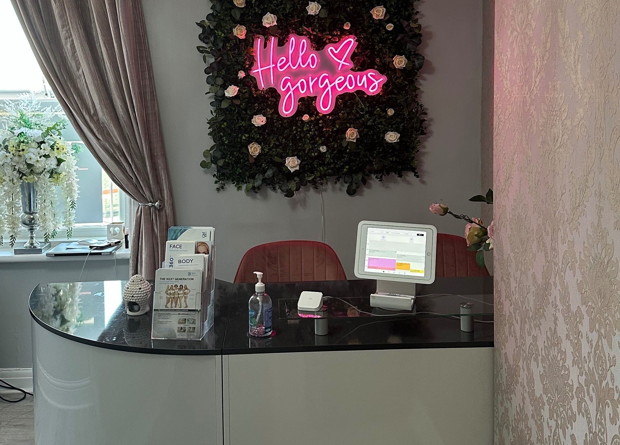 Reception area at Totally Transformed, Newcastle upon Tyne, with 'Hello Gorgeous' neon sign.