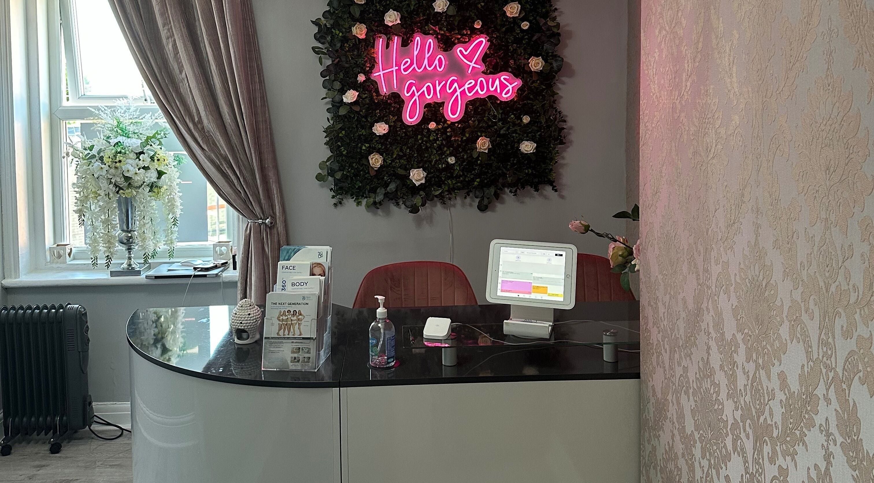 Reception area at Totally Transformed, Newcastle upon Tyne, with 'Hello Gorgeous' neon sign.