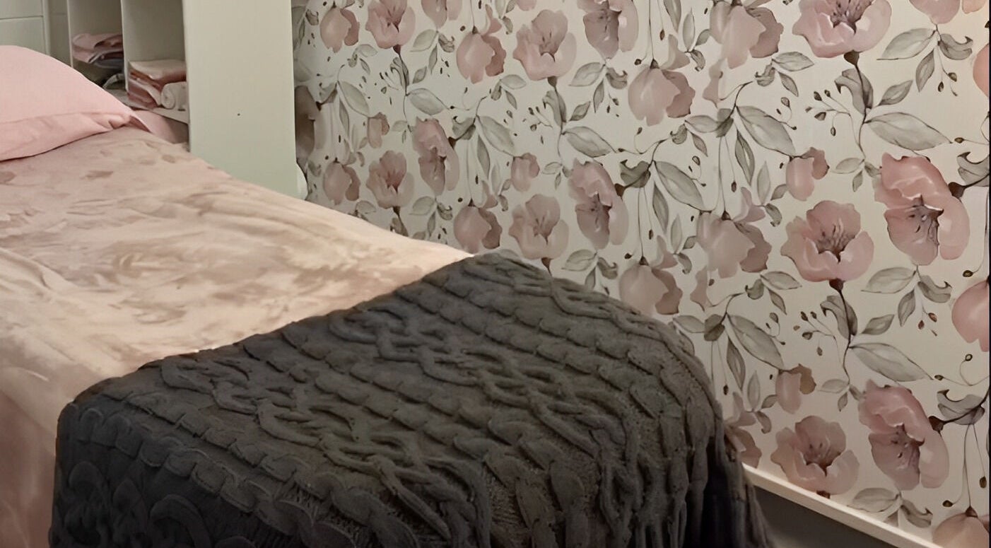 Cozy treatment room at Amabilia Beauty in Charmhaven, New South Wales, AU, with floral wallpaper and plush bedding.