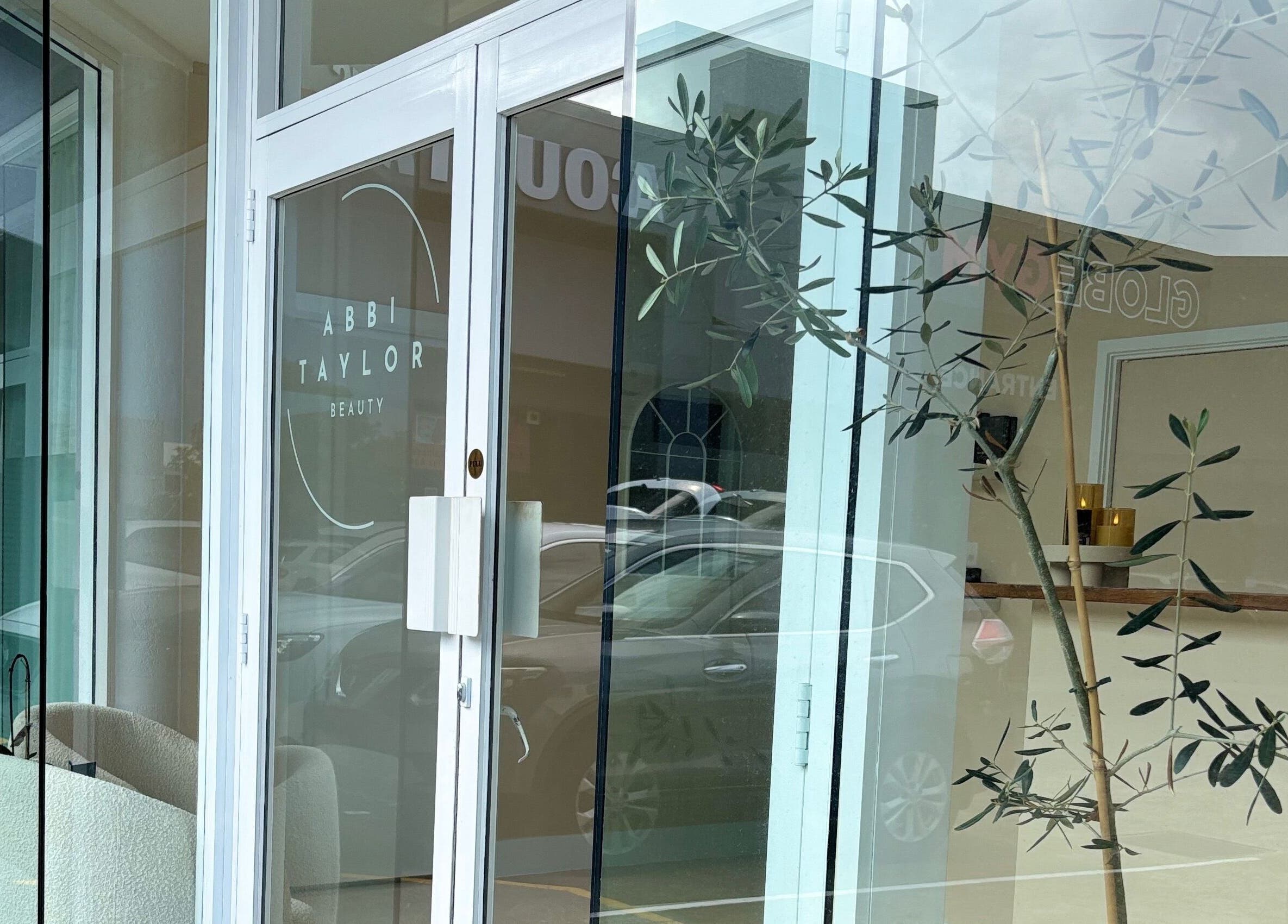 Front entrance of Base Beauty Studio in Burleigh Waters, Queensland, AU featuring glass doors with stylish decor.