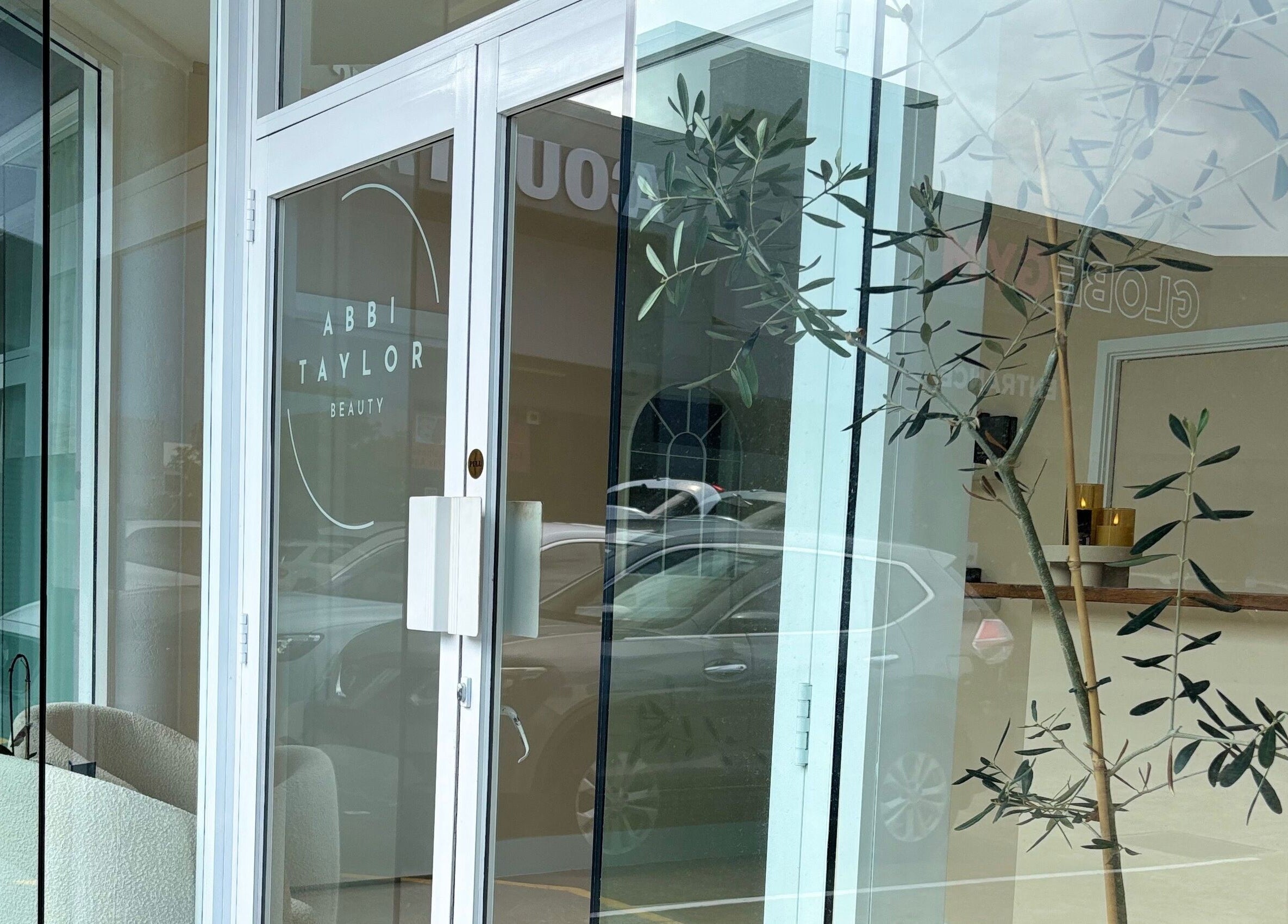 Front entrance of Base Beauty Studio in Burleigh Waters, Queensland, AU featuring glass doors with stylish decor.