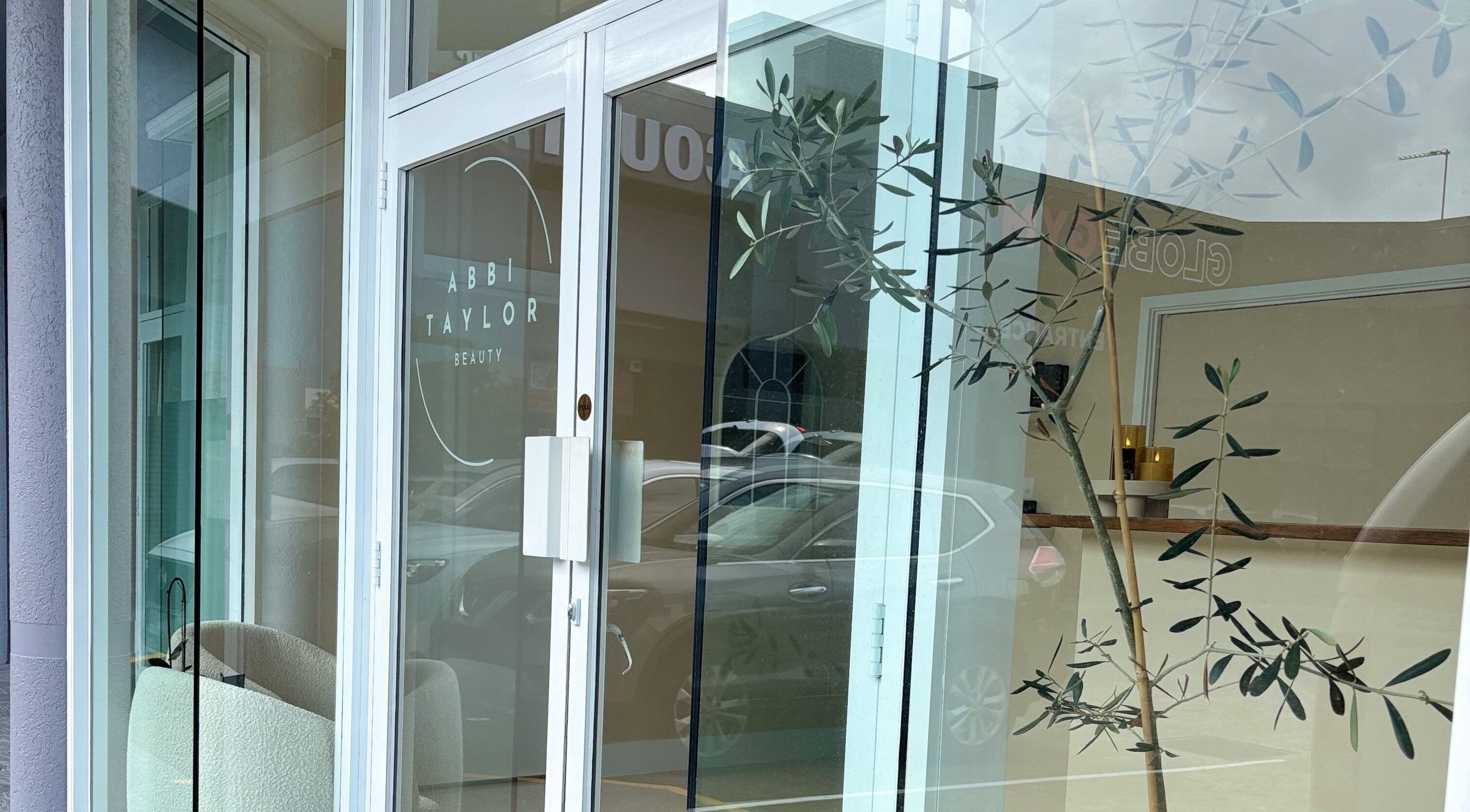 Front entrance of Base Beauty Studio in Burleigh Waters, Queensland, AU featuring glass doors with stylish decor.