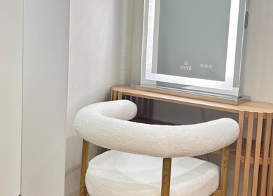 Elegant vanity setup at Lotus Crown Spa, Joondalup, WA, AU with chic chair and illuminated mirror.