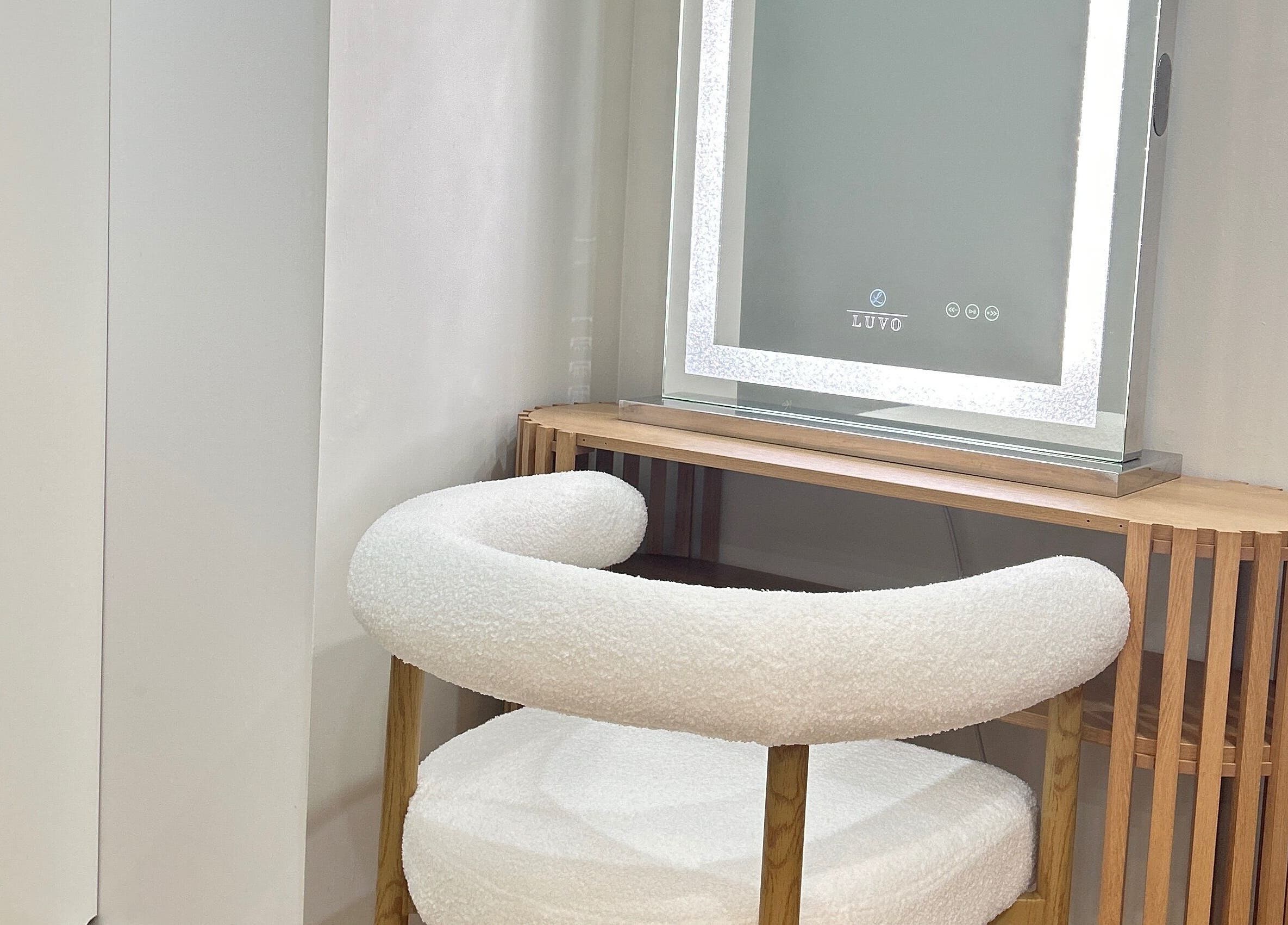 Elegant vanity setup at Lotus Crown Spa, Joondalup, WA, AU with chic chair and illuminated mirror.