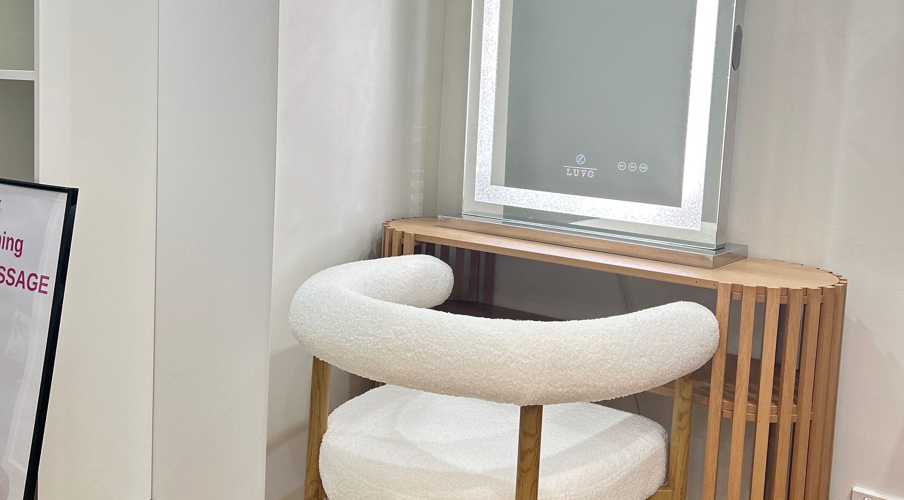 Elegant vanity setup at Lotus Crown Spa, Joondalup, WA, AU with chic chair and illuminated mirror.