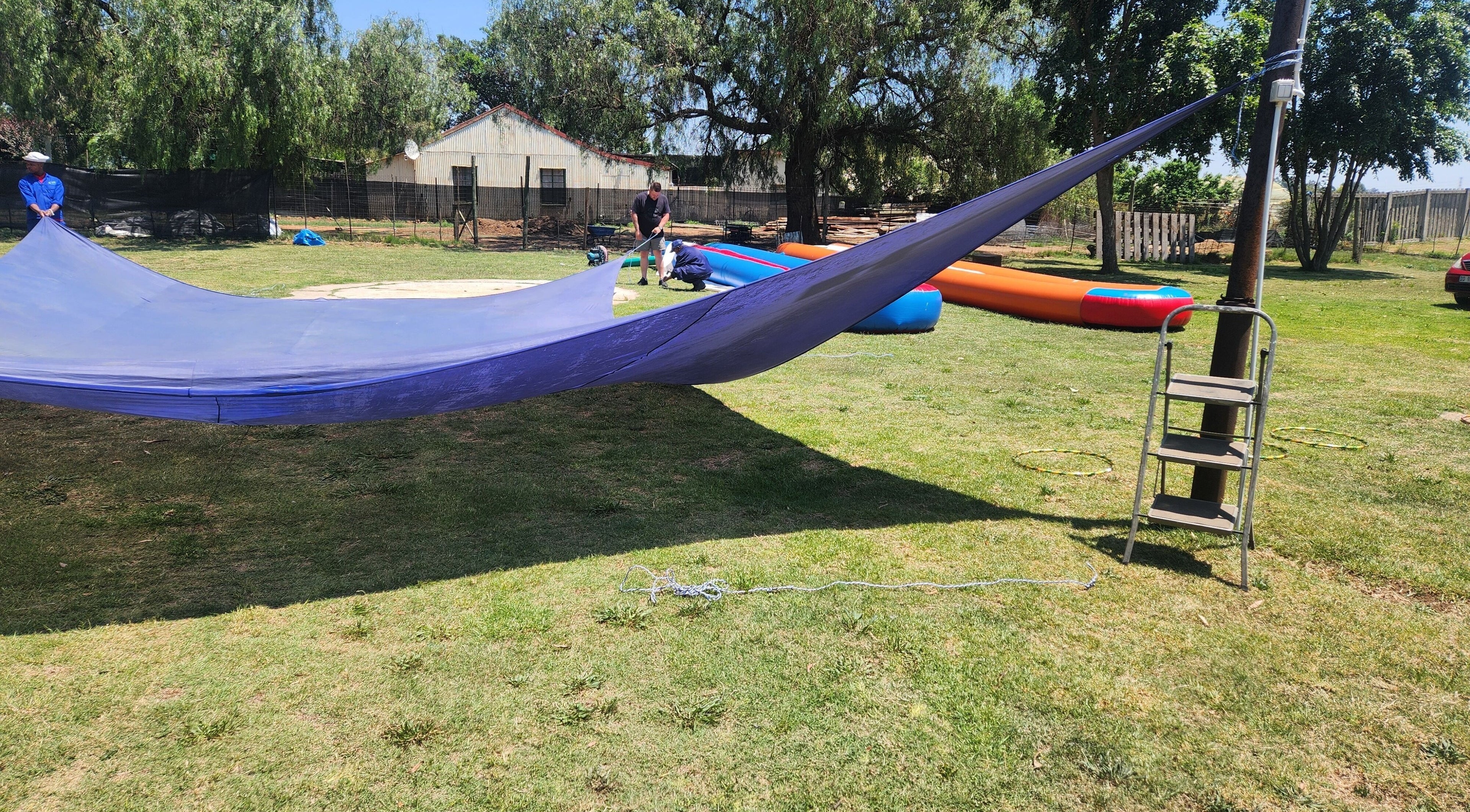 MC Cleaning team setting up vibrant outdoor shade in Springs, Gauteng, ZA under clear skies.