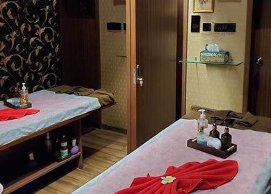 Cozy massage room at Myo Thai Spa in Ooty, Tamil Nadu, IN. Features two tables with warm lighting.