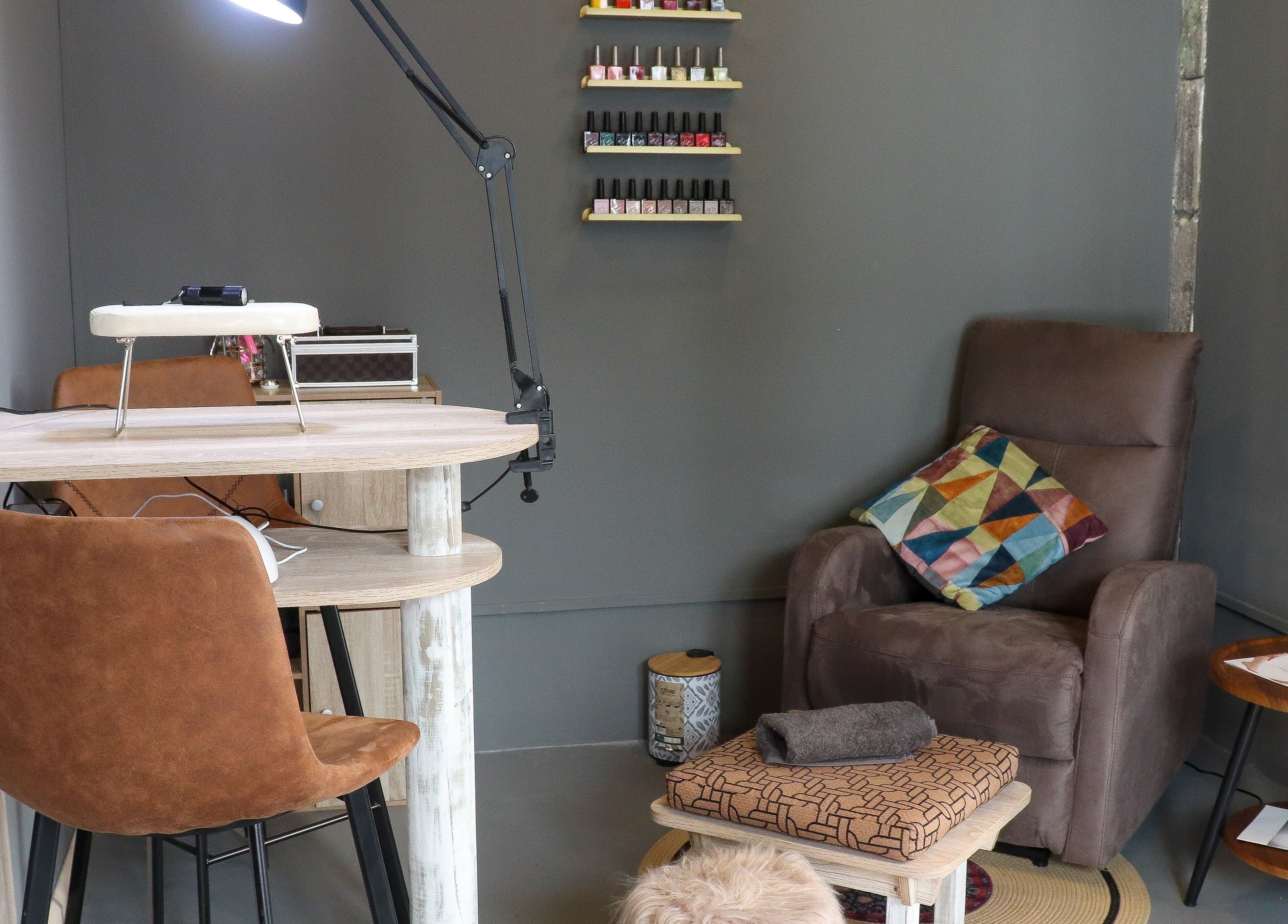 Relaxing nail salon setup at Aesthe, Port Louis, Port Louis District, MU featuring comfy chairs and nail polish display.