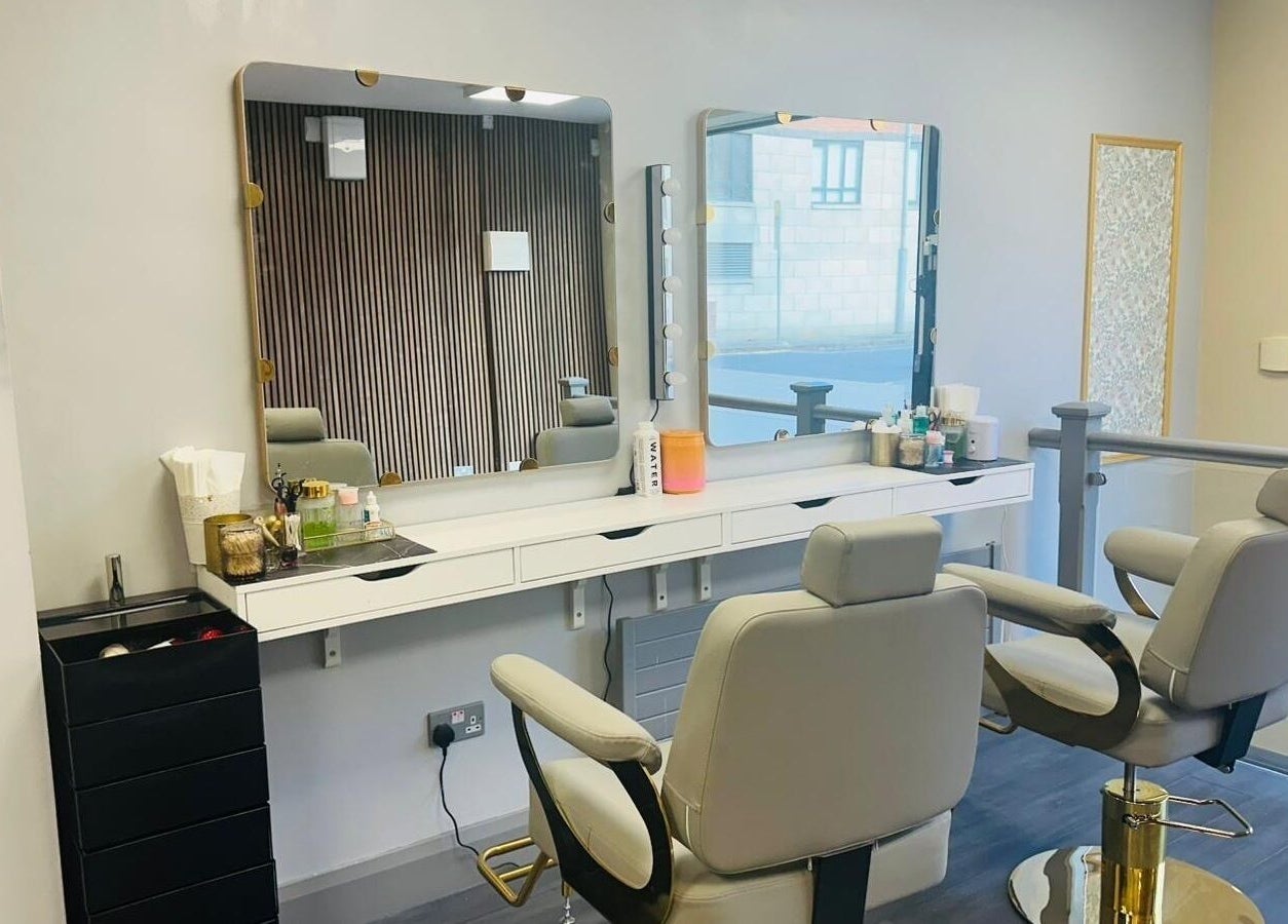 Modern setup at Naina Brow Bar, Dublin7, County Dublin, IE, featuring plush chairs and lit mirrors.