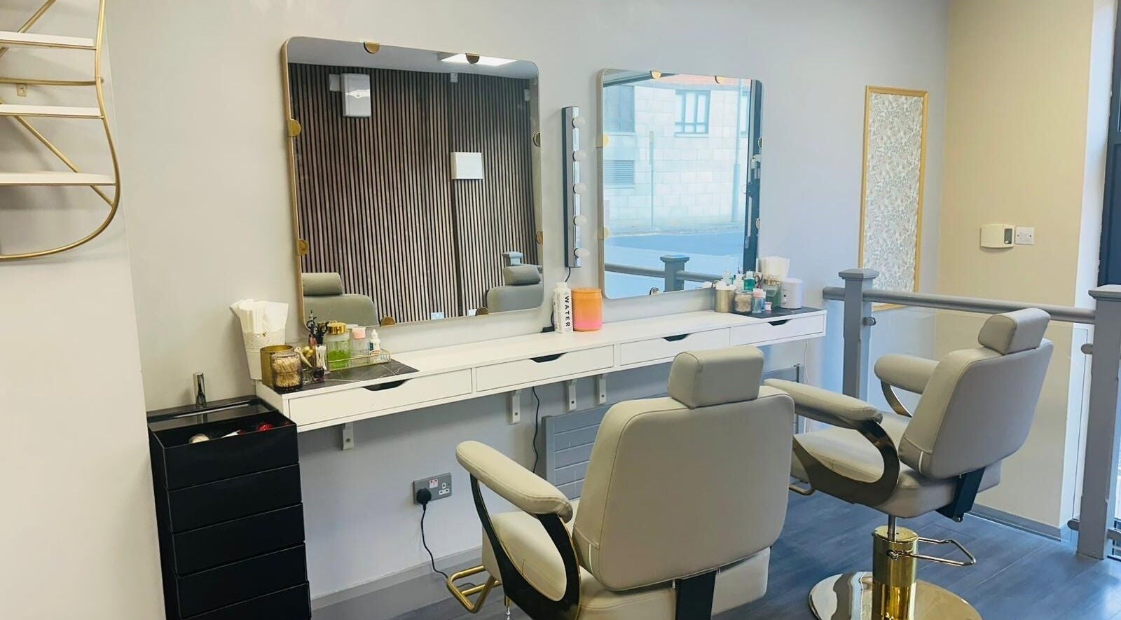 Modern setup at Naina Brow Bar, Dublin7, County Dublin, IE, featuring plush chairs and lit mirrors.