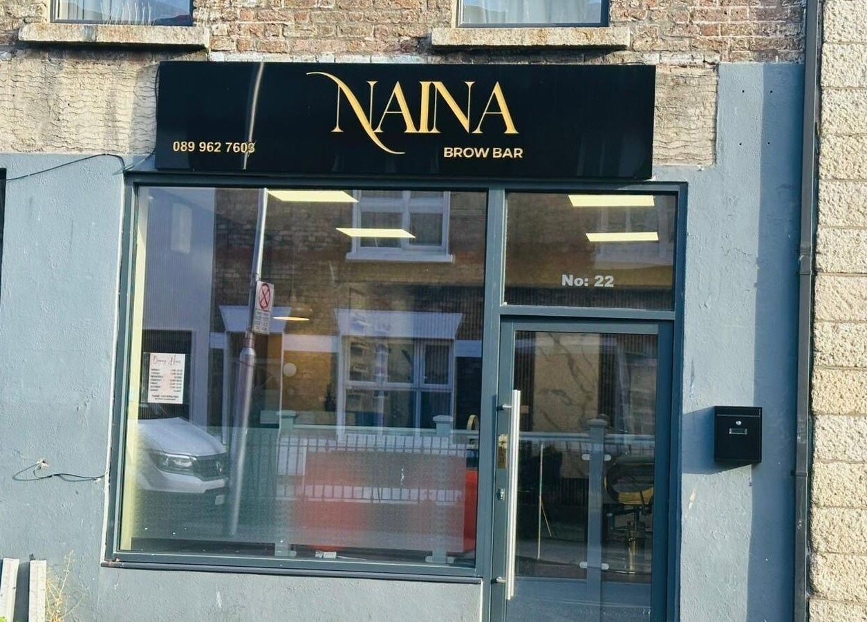 Exterior of Naina Brow Bar in Dublin7, County Dublin, IE. Modern black sign above large window.