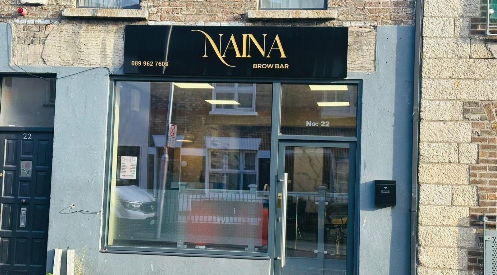 Exterior of Naina Brow Bar in Dublin7, County Dublin, IE. Modern black sign above large window.