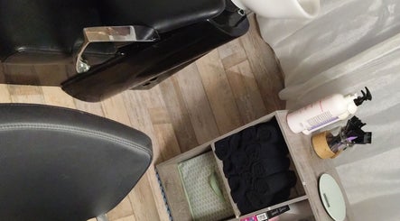 Espace de soins élégant chez DC Coiffure, Saint-martin-de-valgalgues, Occitanie, FR, mettant en valeur un fauteuil noir.