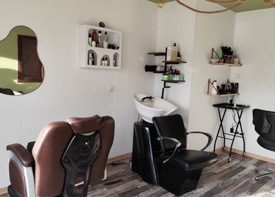 Intérieur moderne de DC Coiffure à Saint-martin-de-valgalgues, Occitanie, FR, avec fauteuils élégants et équipements de coiffure.