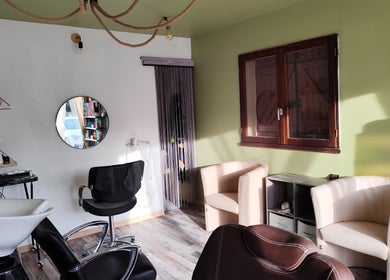 Intérieur chic de DC Coiffure à Saint-martin-de-valgalgues, Occitanie, FR avec fauteuils et miroir moderne.