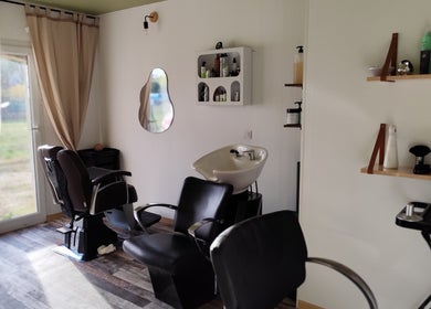 Intérieur chic de DC Coiffure à Saint-martin-de-valgalgues, Occitanie, FR avec fauteuils modernes et espace lumineux.