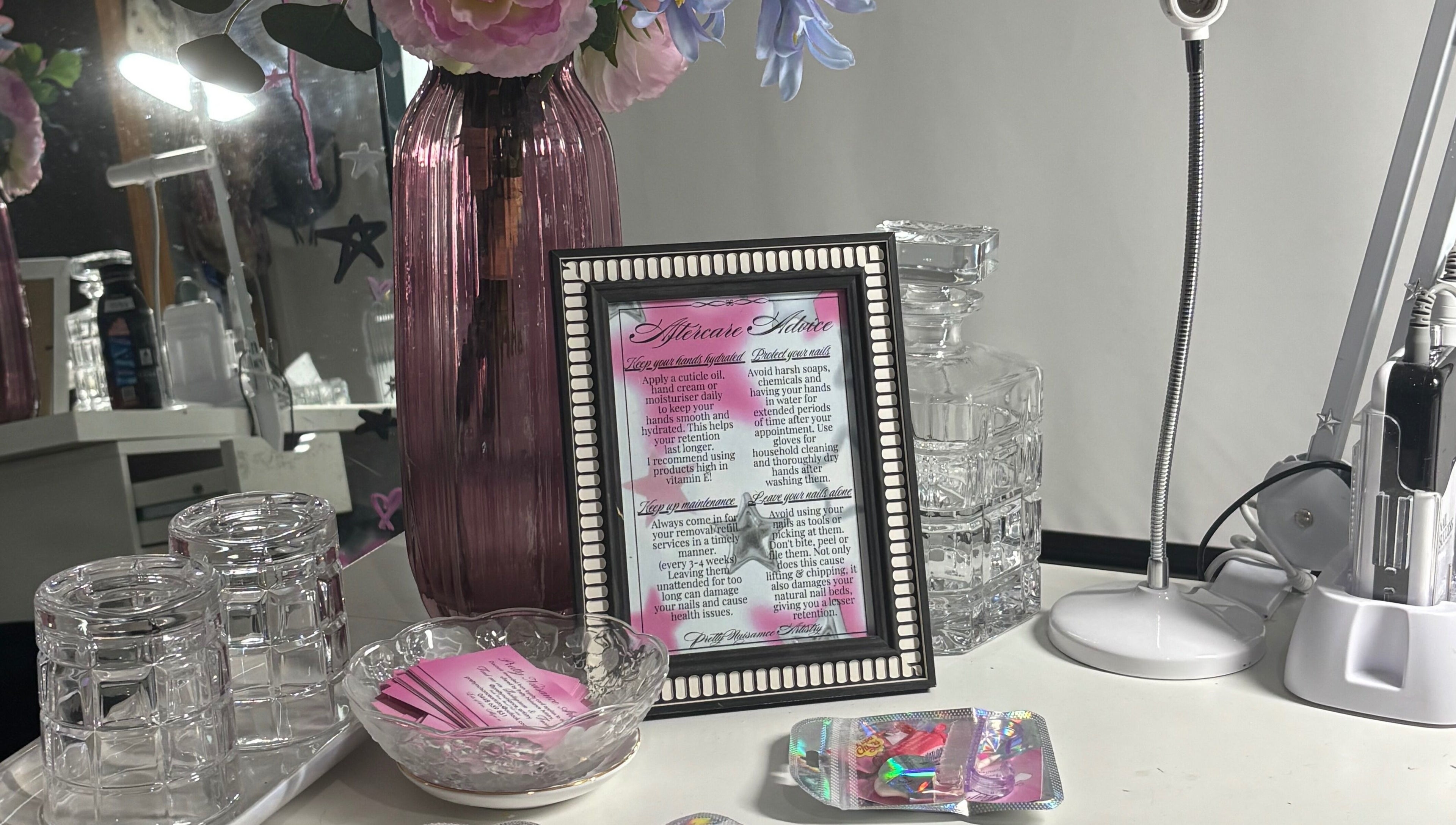 Elegant setup at Pretty Nuisance Artistry, Baldivis, WA with framed advice, vases, and beauty tools.