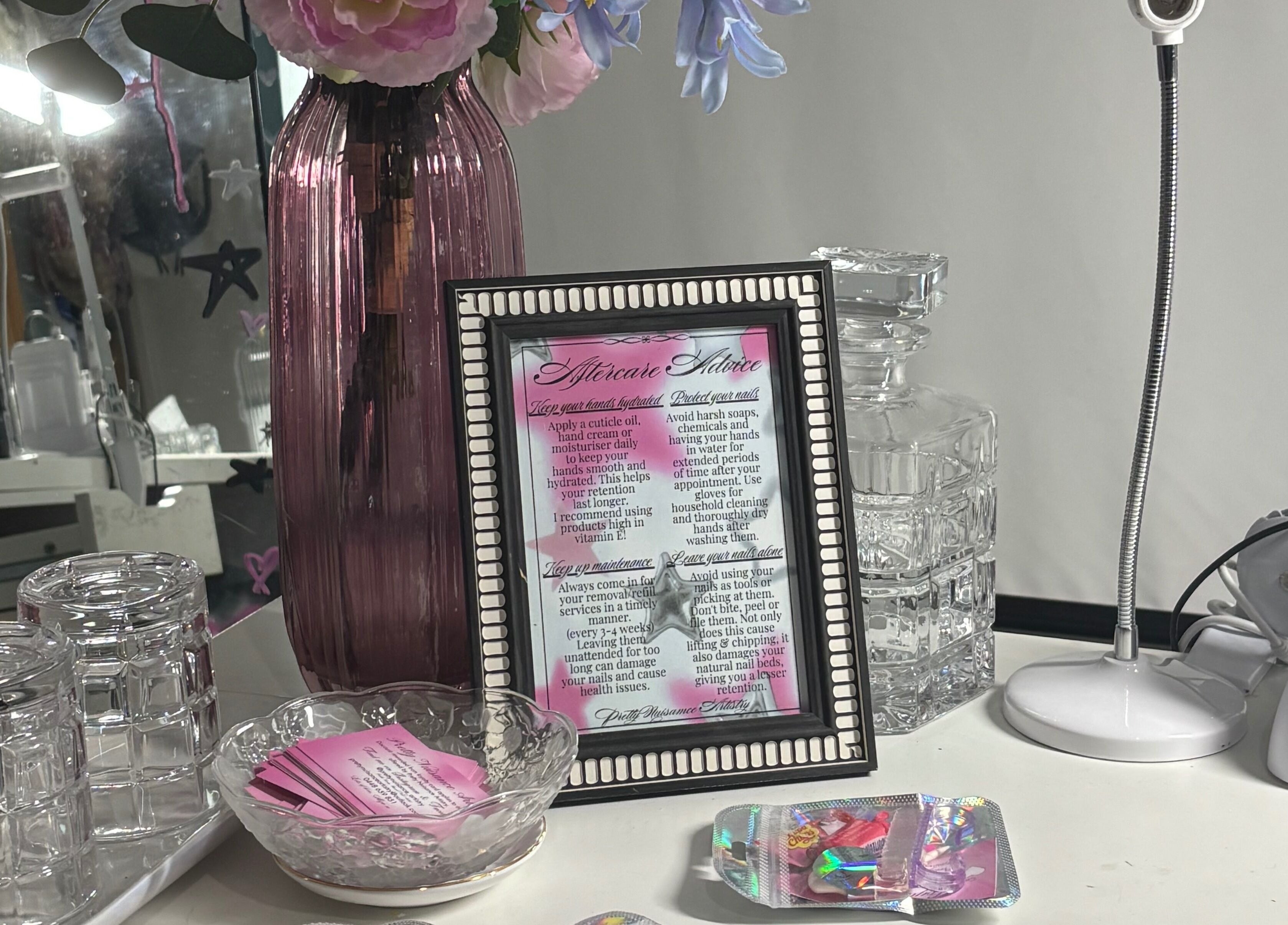 Elegant setup at Pretty Nuisance Artistry, Baldivis, WA with framed advice, vases, and beauty tools.