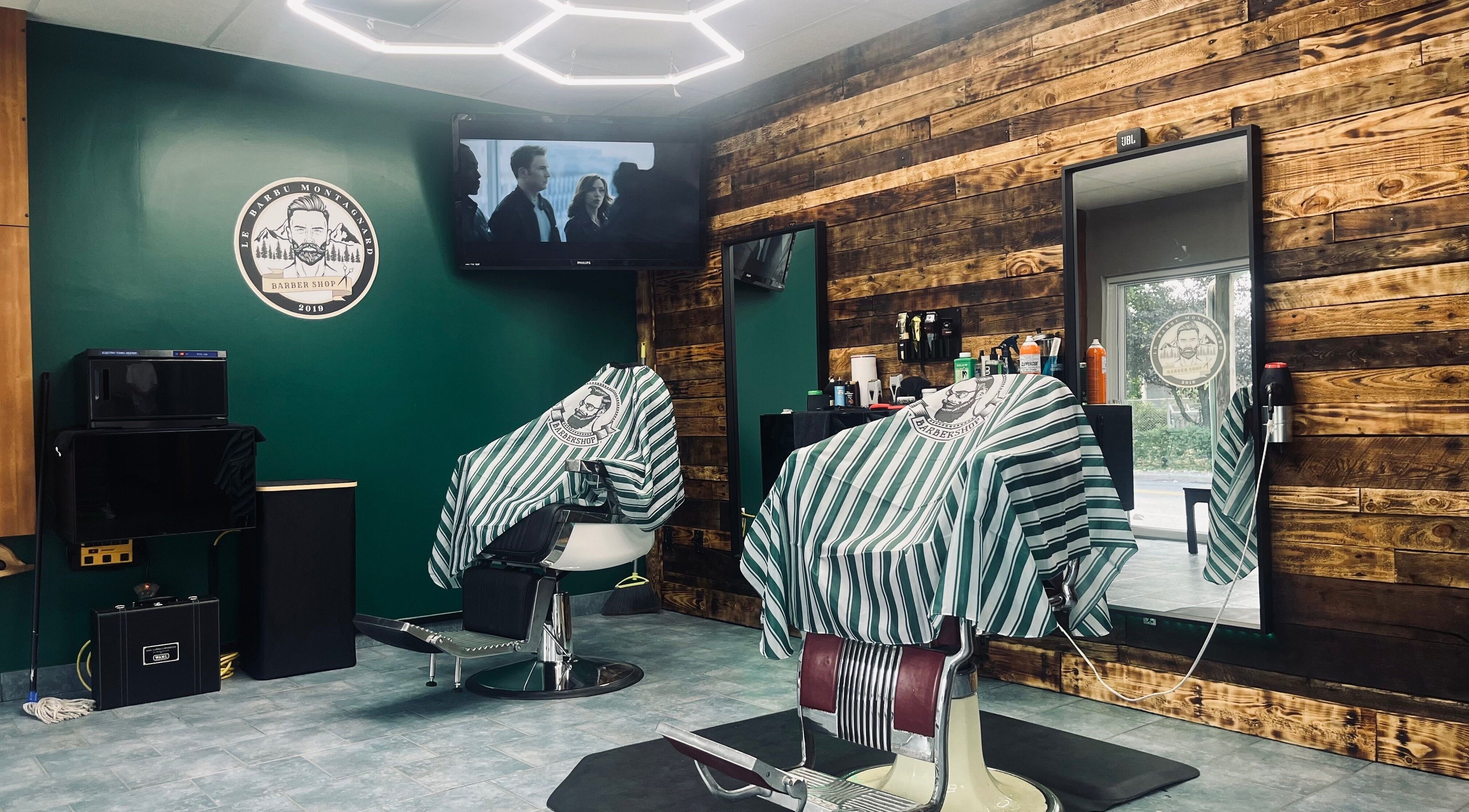 Intérieur stylé du salon Le Barbu Montagnard à Marieville, Québec, CA avec fauteuils et déco boisée.