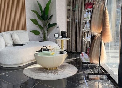 Elegant seating at The Luxury Touch Beauty Salon, Dubai, Dubai, AE, with decor and product shelves.
